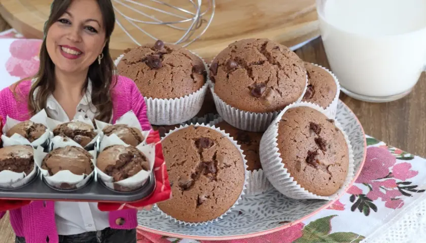 Donna sorridente presenta una teglia di muffin al cioccolato senza burro, perfetti per una colazione golosa.