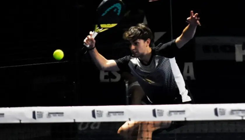 Giovane giocatore di padel colpisce la palla con un potente top spin, concentrato sul gioco.