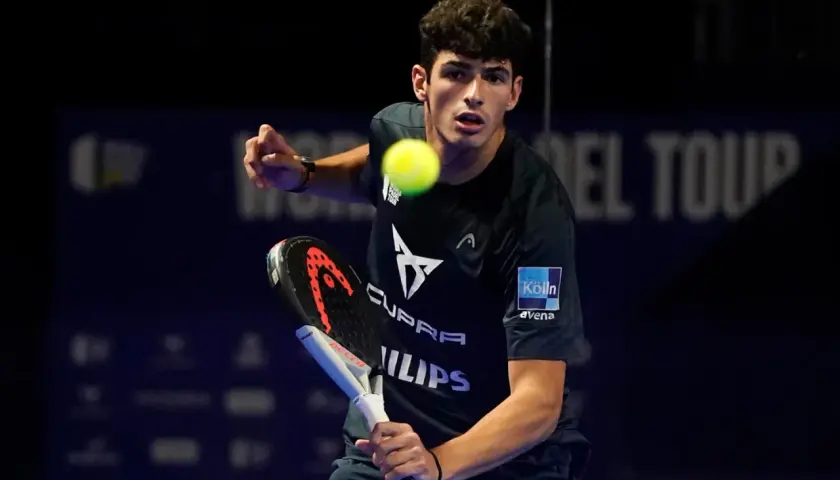 Giovane giocatore di padel in azione, colpisce la palla con la racchetta.