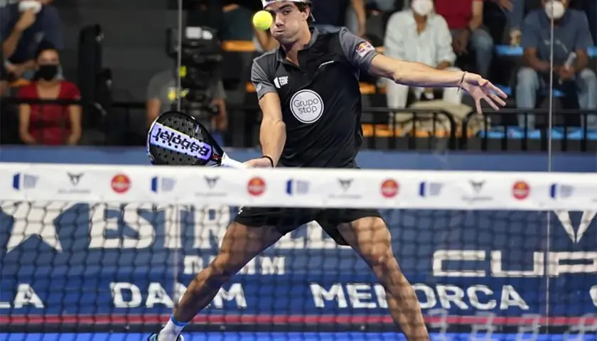 Giocatore di padel in azione, con un perfetto **split step** per colpire la palla.
