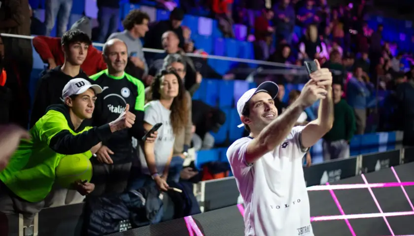 Luigi Carraro, giocatore di tennis, scatta un selfie con i tifosi entusiasti sugli spalti.