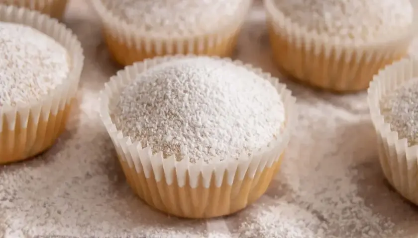 Muffin senza uova, soffici e spolverati di zucchero a velo, pronti per essere gustati.