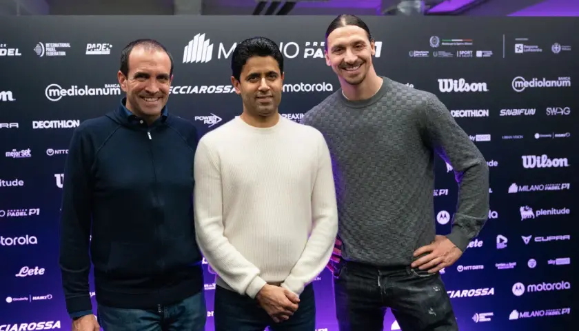 Zlatan Ibrahimović sorride con due uomini davanti a uno sfondo con loghi di padel.