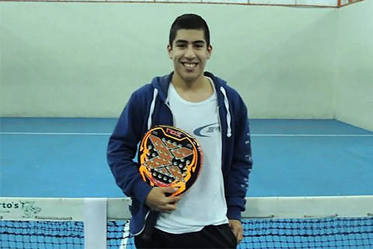 Federico Chingotto sorride con la sua racchetta da padel, pronto per la partita.