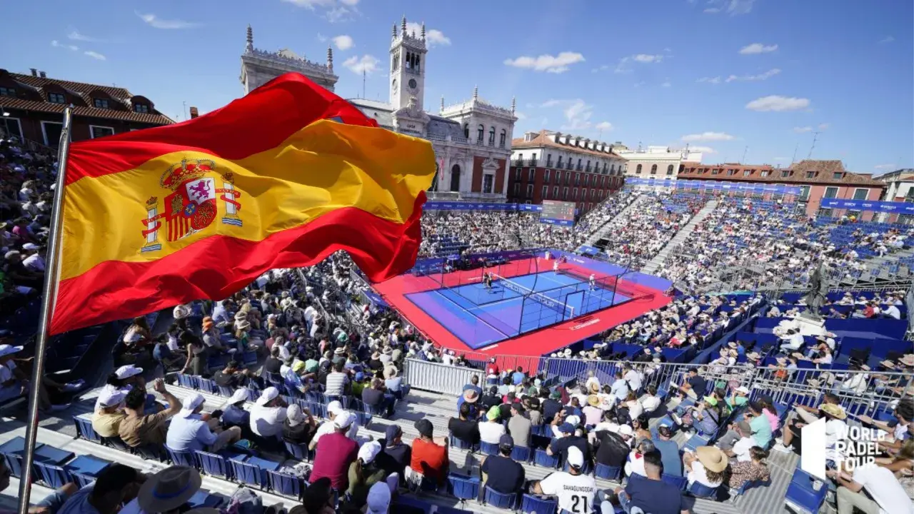 Bandiera spagnola sventola su un campo da padel gremito di spettatori. Atmosfera vibrante per il padel in Spagna.