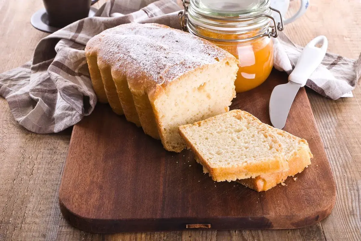Plumcake senza uova spolverato di zucchero a velo, pronto da gustare con marmellata.