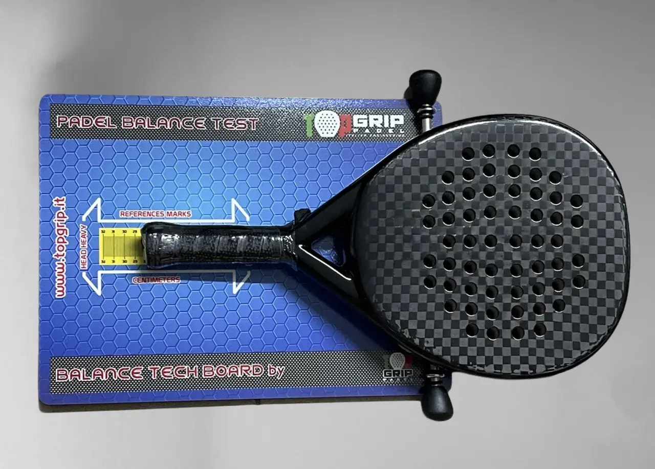 Racchetta da padel su tavola per test di bilanciamento. Misura il bilanciamento della racchetta per un gioco ottimale.