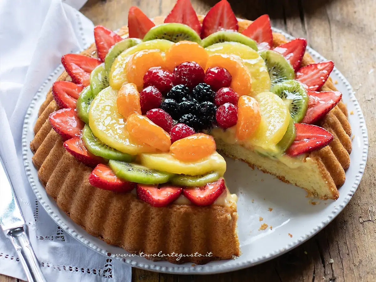 Una crostata morbida alla frutta, con fragole, kiwi, mandarini e frutti di bosco, su una base di crema pasticcera.