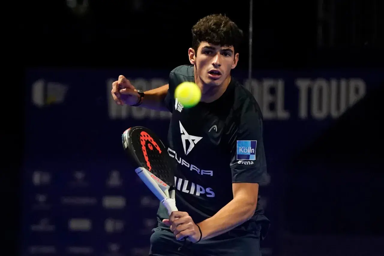 Giovane giocatore di padel in azione, colpisce la palla con la racchetta.
