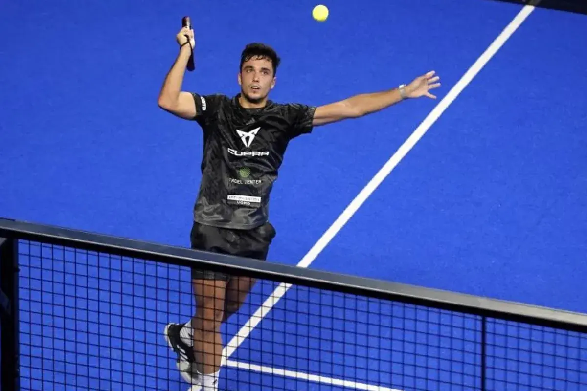 Giocatore di padel in azione, colpisce la palla con un lob perfetto.