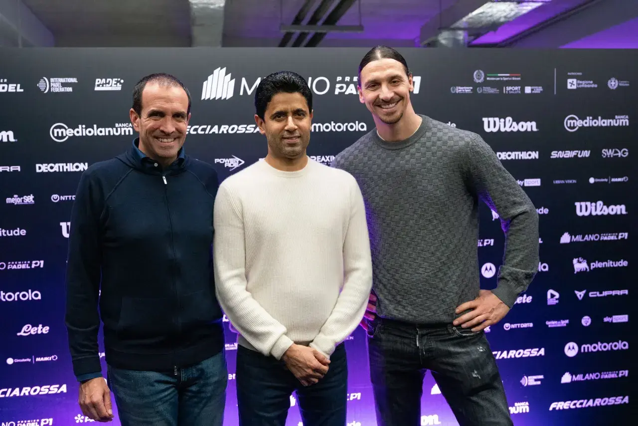 Zlatan Ibrahimović sorride con due uomini davanti a uno sfondo con loghi di padel.