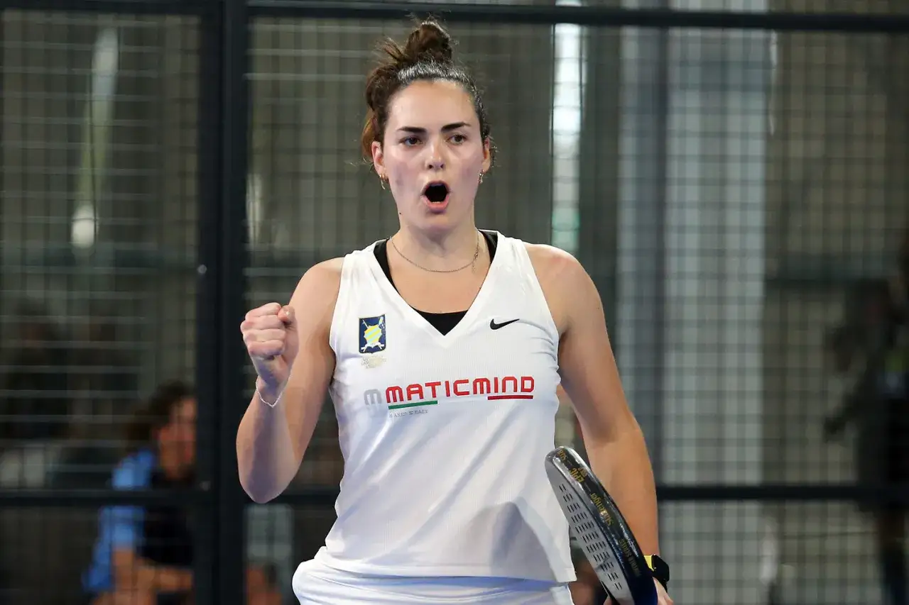 Carolina Orsi esulta in campo da padel, con la racchetta in mano e il pugno chiuso.