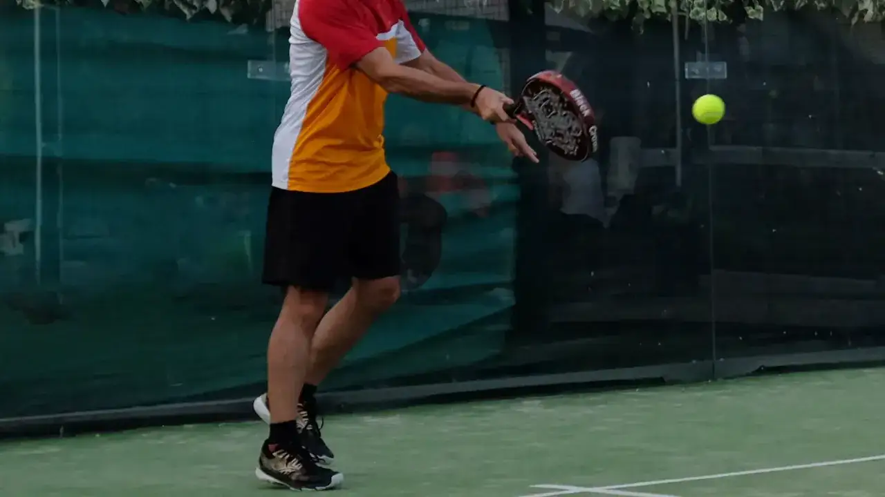 Giocatore di padel in azione, colpo al volo. Per migliorare a padel, osserva la tecnica e la posizione.