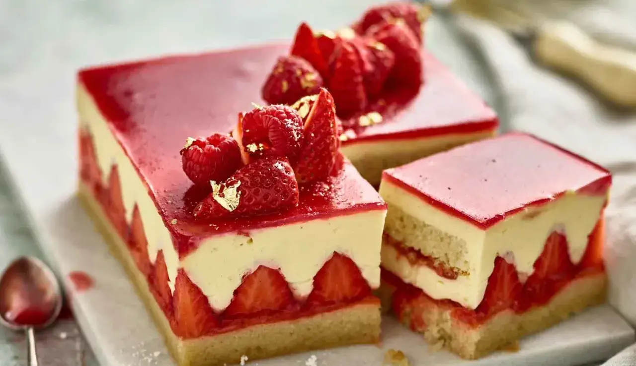 Deliziosi dolci con fragole, crema e gelatina rossa, decorati con frutti di bosco e foglia d'oro.