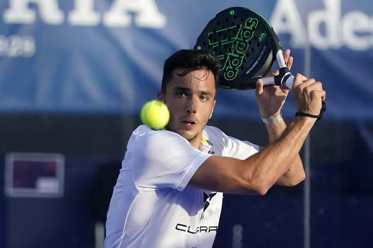 Un giocatore di padel, con la racchetta Adidas in mano, colpisce la palla. Alba Galán, concentrato, si prepara al colpo.