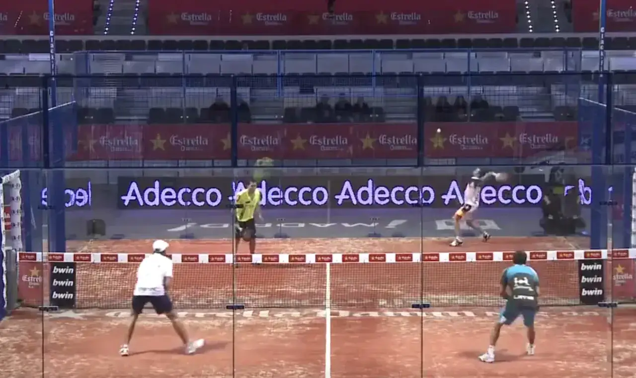 Partita di padel con giocatori in azione. Un giocatore colpisce la palla con la sua cuchilla padel, mentre un avversario si prepara a rispondere.
