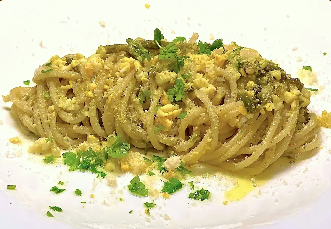 Un piatto di spaghetti con asparagi selvatici, uova sbriciolate e prezzemolo fresco. Un classico della cucina italiana.