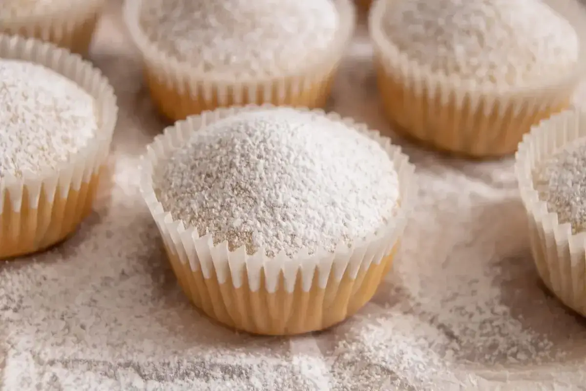 Muffin senza uova, soffici e spolverati di zucchero a velo, pronti per essere gustati.
