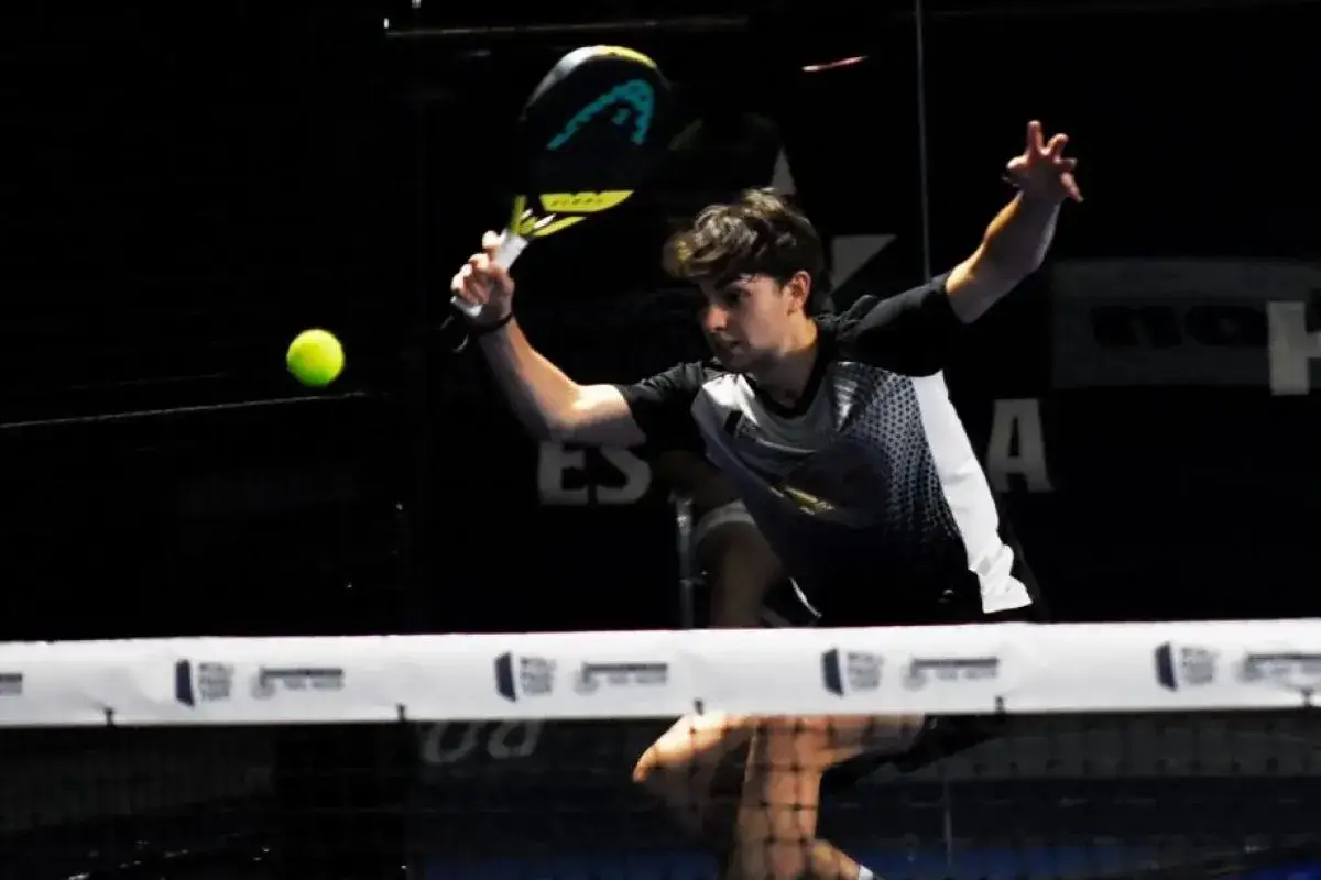 Giocatore di padel in azione, colpisce la palla con un potente top spin.