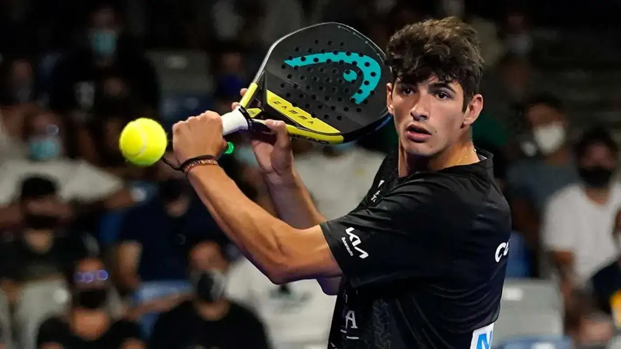 Giovane giocatore di padel, con racchetta e palla in mano, pronto a colpire.
