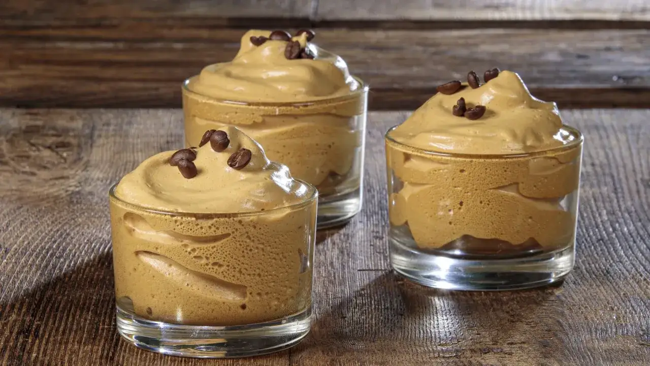 Tre bicchierini di soffice crema di caff&egrave;, perfetta ricetta crema di caff&egrave; senza panna, guarniti con chicchi tostati.