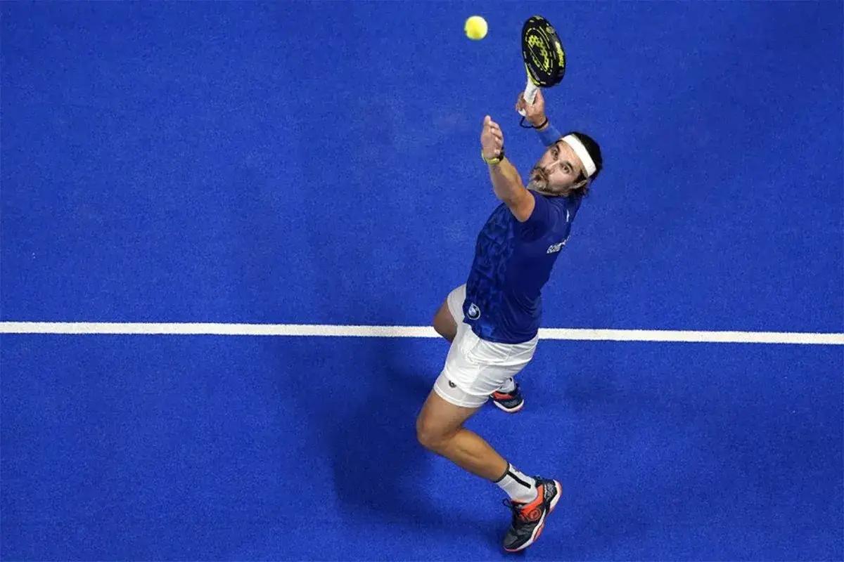 Giocatore di padel in azione, pronto a eseguire uno smash x3 con potenza e precisione sul campo blu.