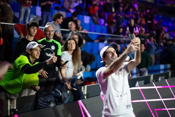 Luigi Carraro, giocatore di tennis, scatta un selfie con i tifosi entusiasti sugli spalti.